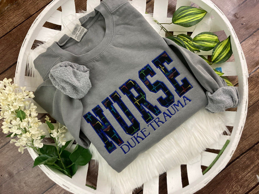 Nurse sweatshirt with rainbow heartbeat fabric applique