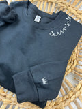 Custom sweatshirt with cursive name embroidery along the collar