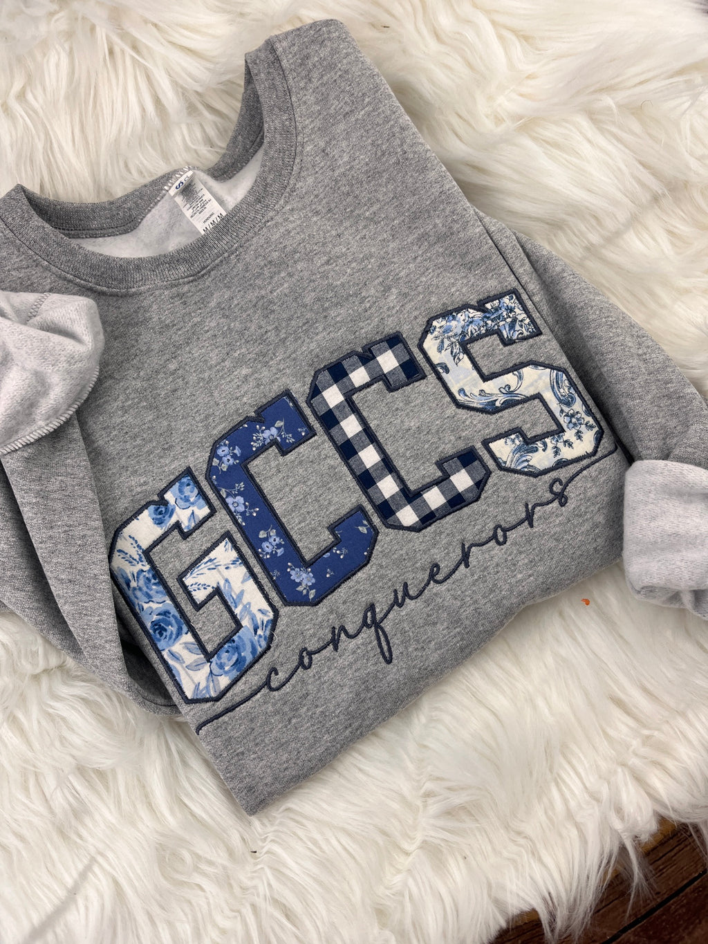 Close-up of GCCS mixed blue fabric appliqué and Conquerors embroidery