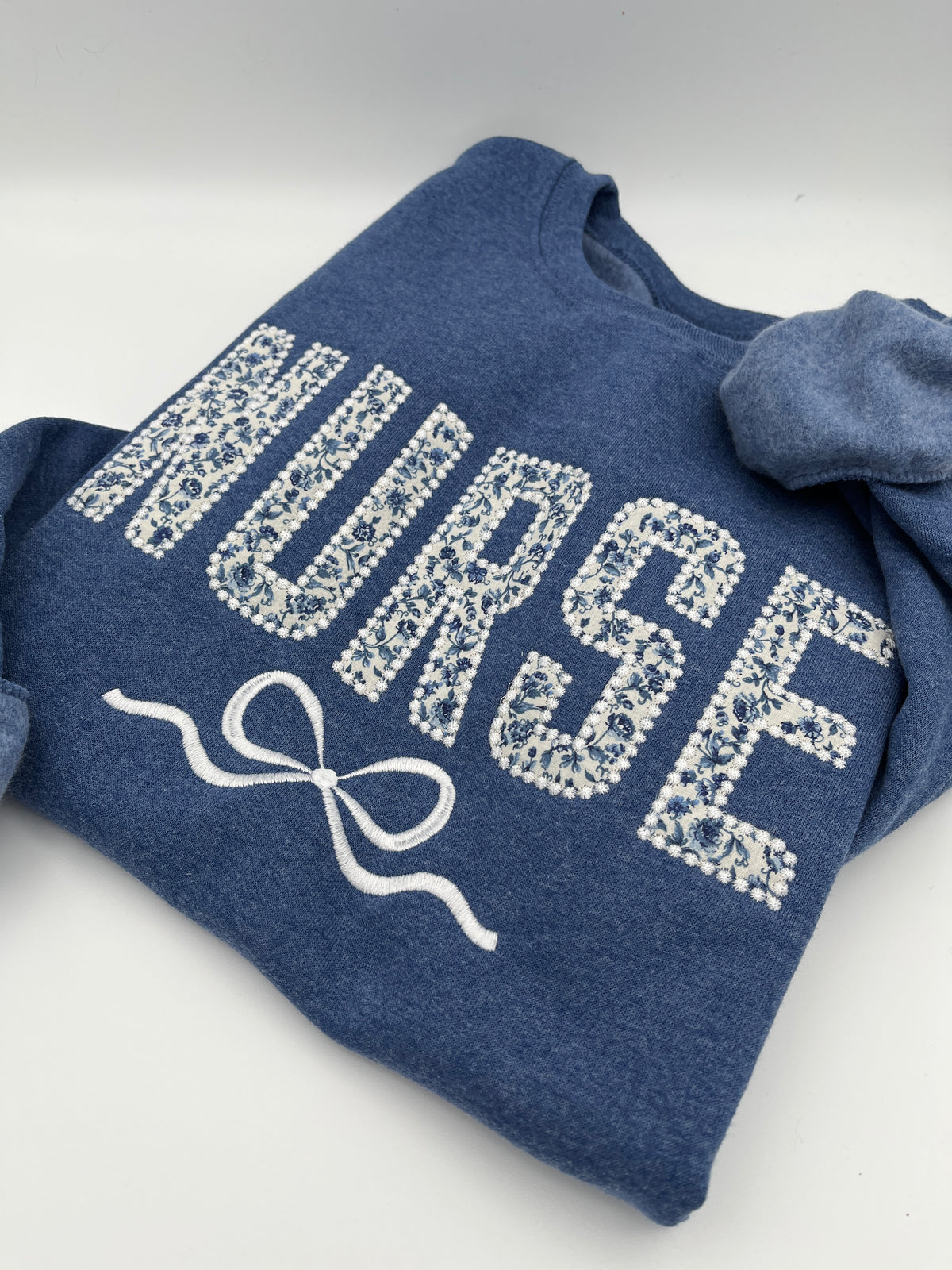 Coquette nurse sweatshirt with applique and embroidered bow - close up view