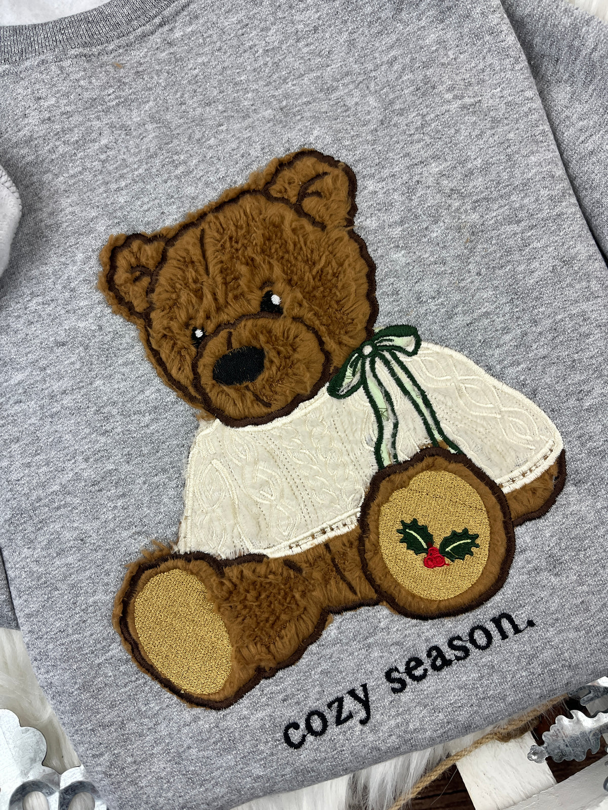 Christmas bear sweatshirt with brown sherpa applique and holly paw design - detail view