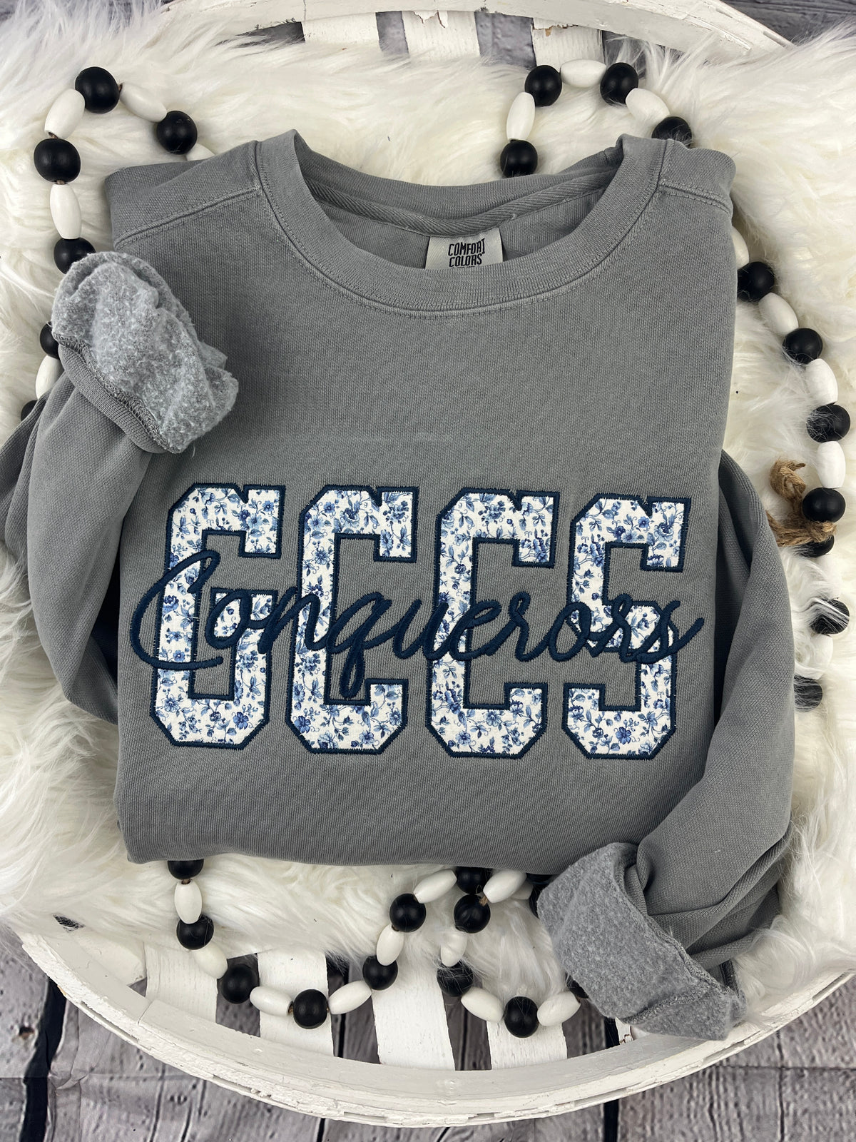 School spirit sweatshirt with floral blue applique and cursive script - detail view