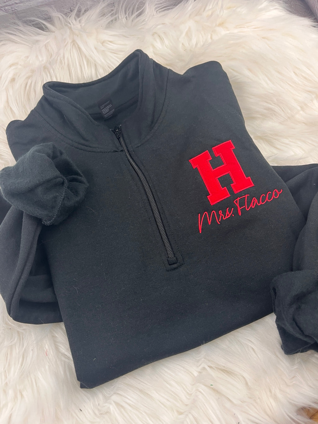 Black quarter-zip with red applique H and Mrs. Flacco embroidered in red