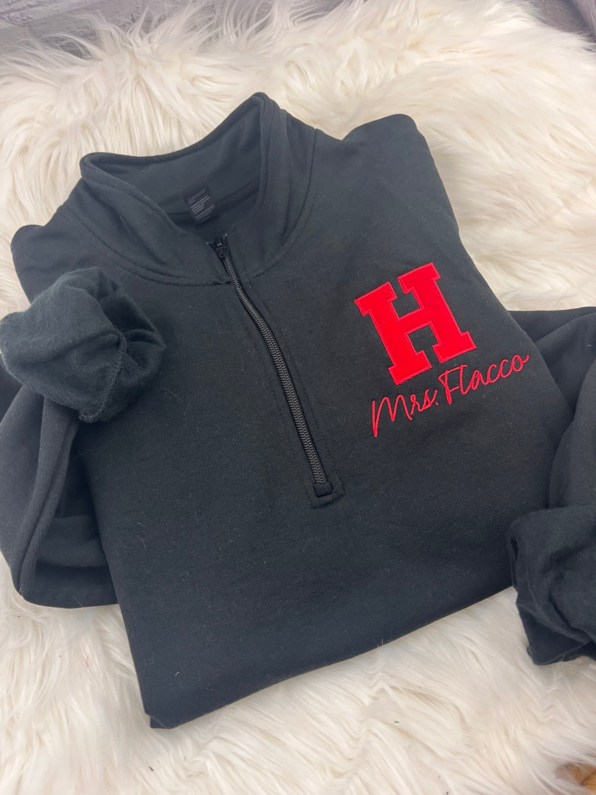 Black quarter-zip with red applique H and Mrs. Flacco embroidered in red