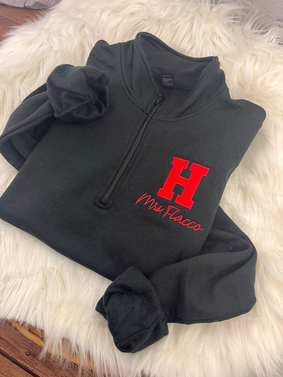 Applique H quarter-zip with teacher name, angled view