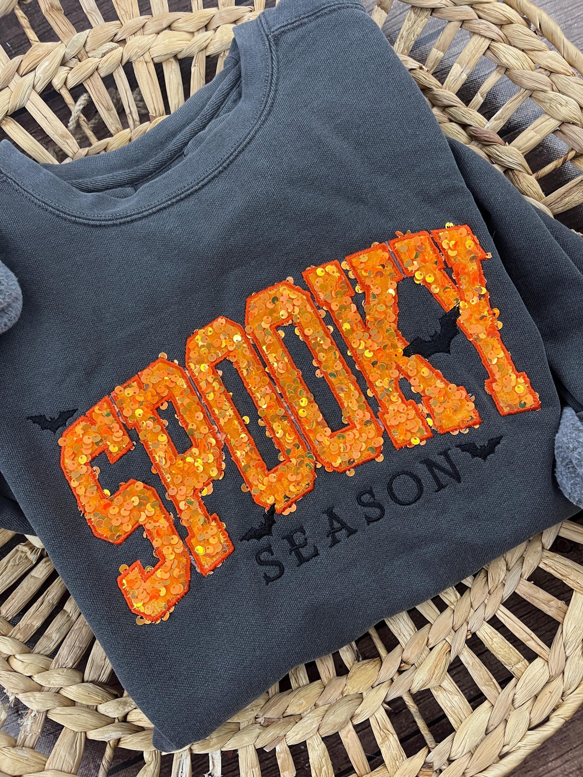 Halloween crewneck sweatshirt with orange sequin SPOOKY applique and embroidered bats - detail view
